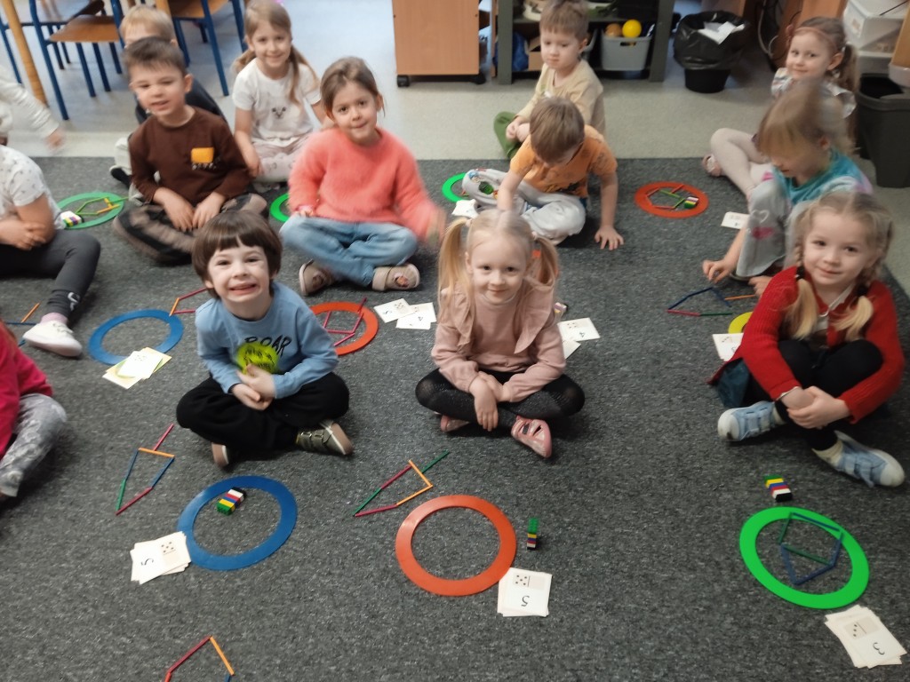 dzieci siedza na dywanie i przeliczaja