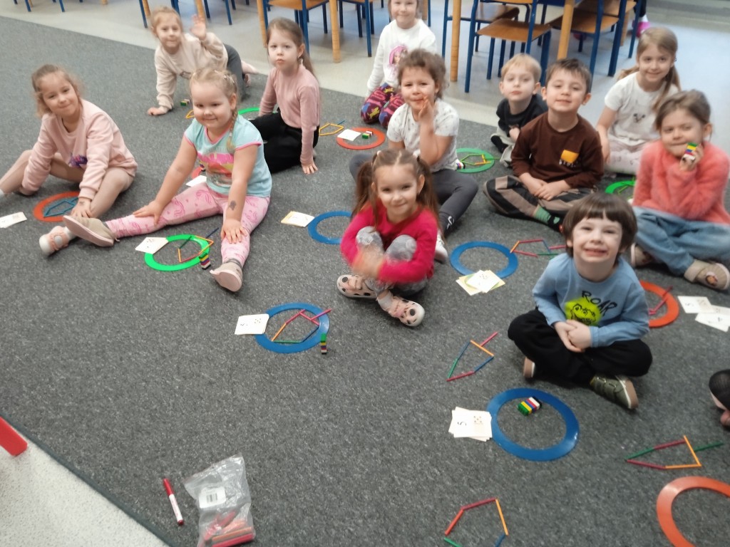 dzieci siedza na dywanie i przeliczaja