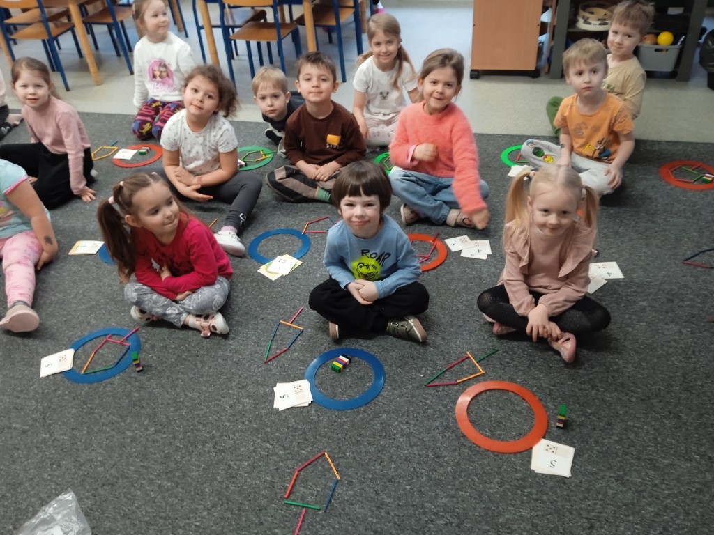 dzieci siedza na dywanie i przeliczaja