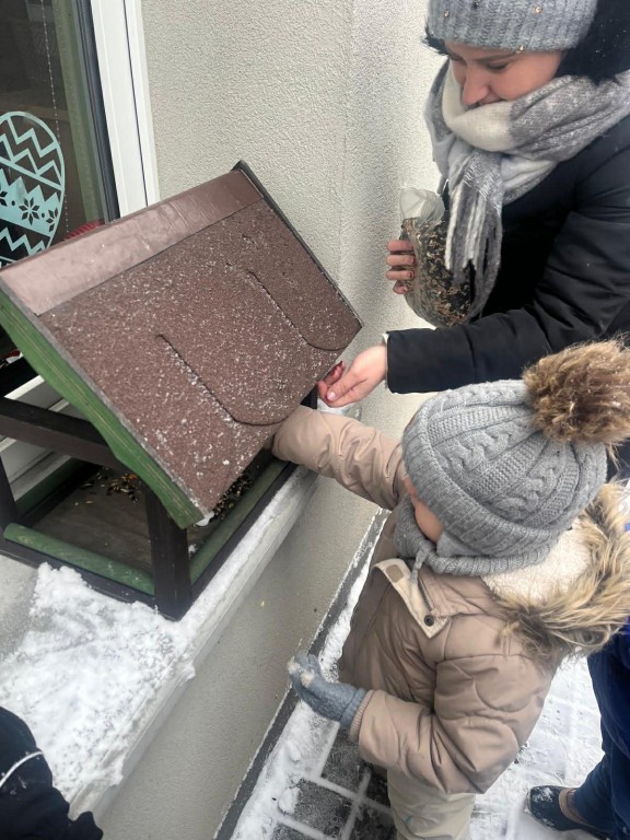 dziewczynka słucha instrukcji karmienia ptaków