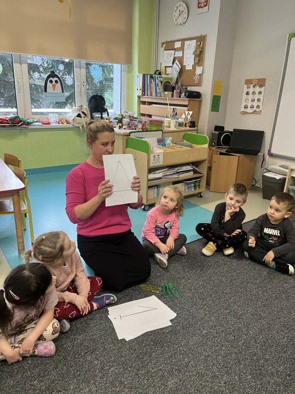 nauczyciel tłumaczy zadanie matematyczne