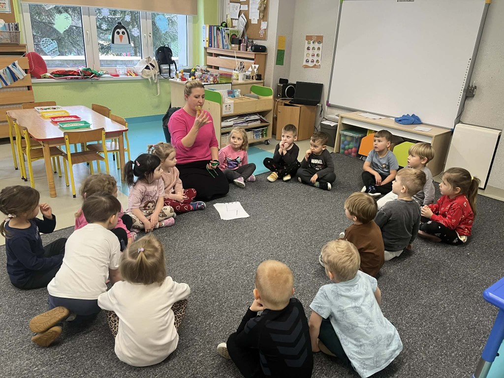 nauczyciel prezentuje jak posługiwać się pipetką