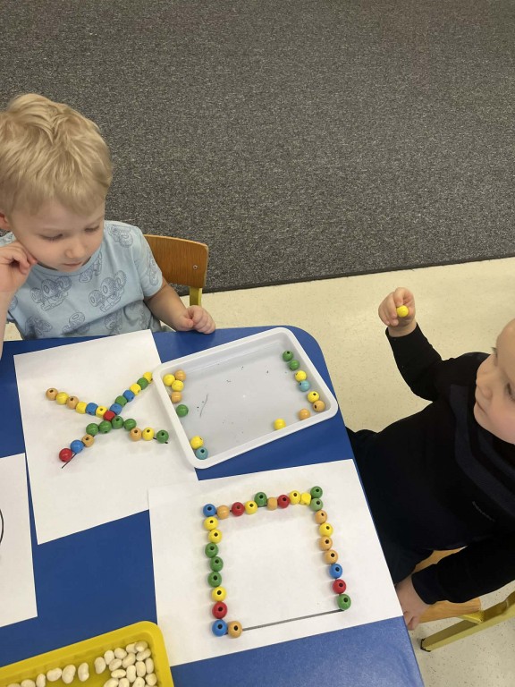 dzieci układają matematyczne kształty i cyfry materiałem sensorycznym