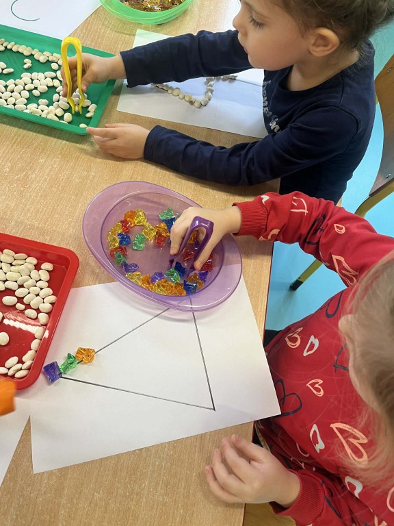 dzieci układają matematyczne kształty i cyfry materiałem sensorycznym