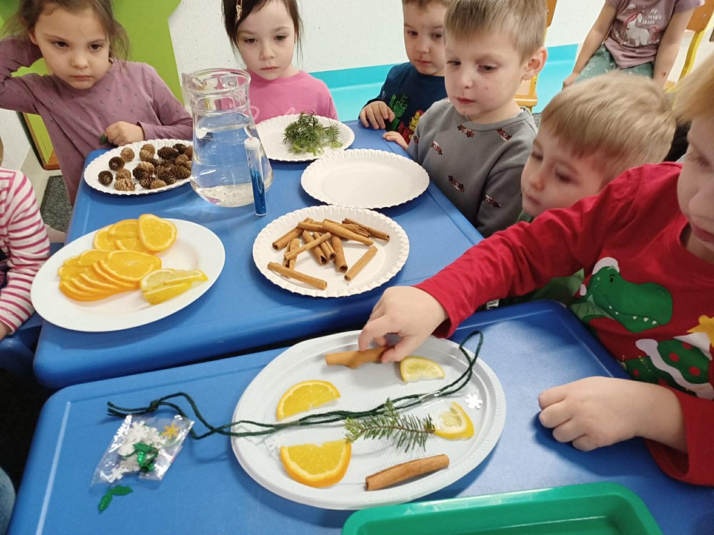 wychowawca i dziecko wlewają wodę do talerzyków