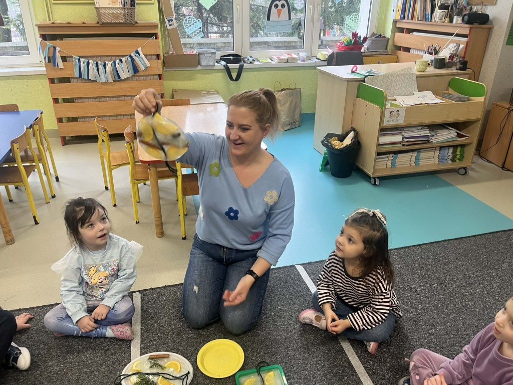 dzieci podają sobie witraże i przyglądają się im