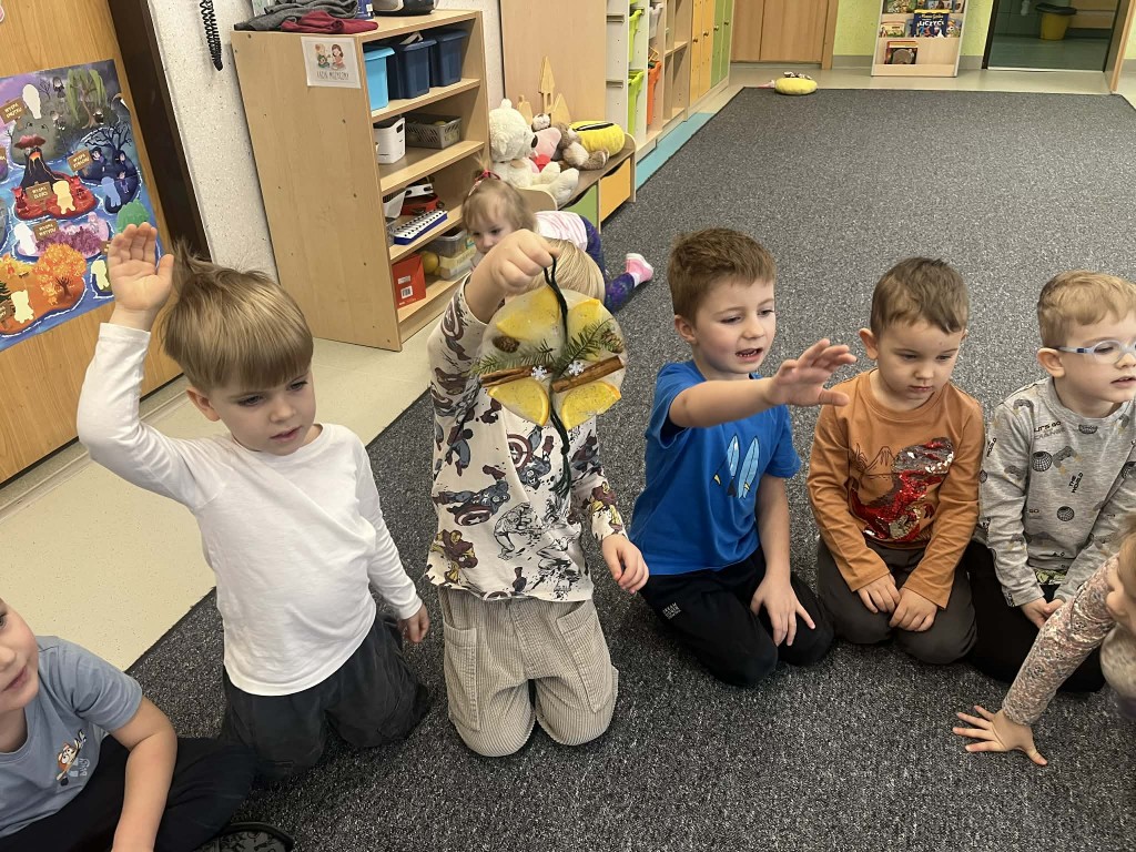 dzieci podają sobie witraże i przyglądają się im