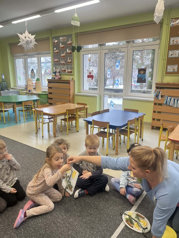 dzieci podają sobie witraże i przyglądają się im