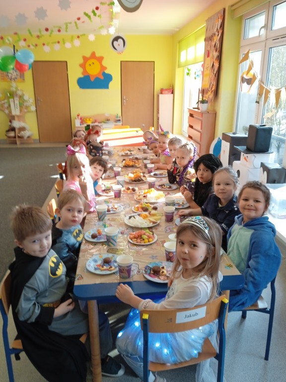 dzieci jedza smakolyki przy stoliku