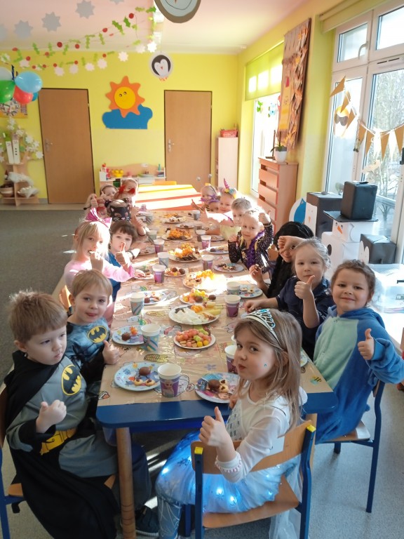 dzieci jedza smakolyki przy stoliku