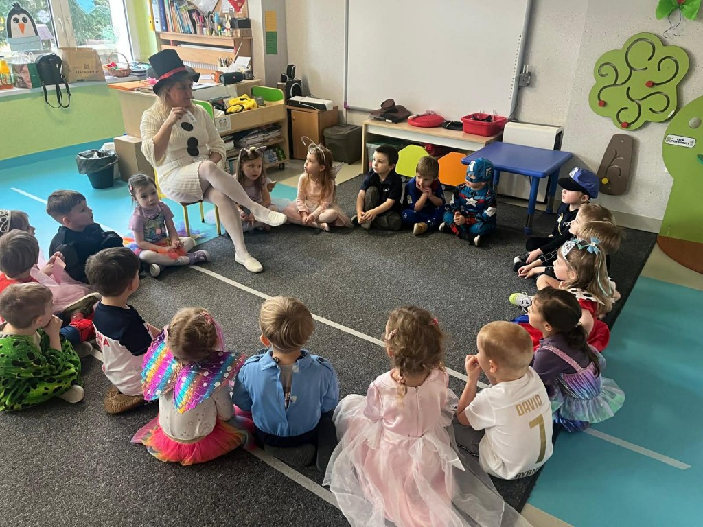 nauczyciel zadaje dzieciom karnawałowe zagadki obrazkowe