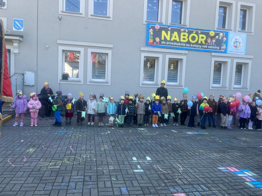 Uroczyste odśpiewanie hymnu przedszkola przed budynkiem placówki