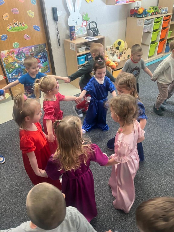 Taniec dzieci w kole oraz dziewczynek w długich sukniach