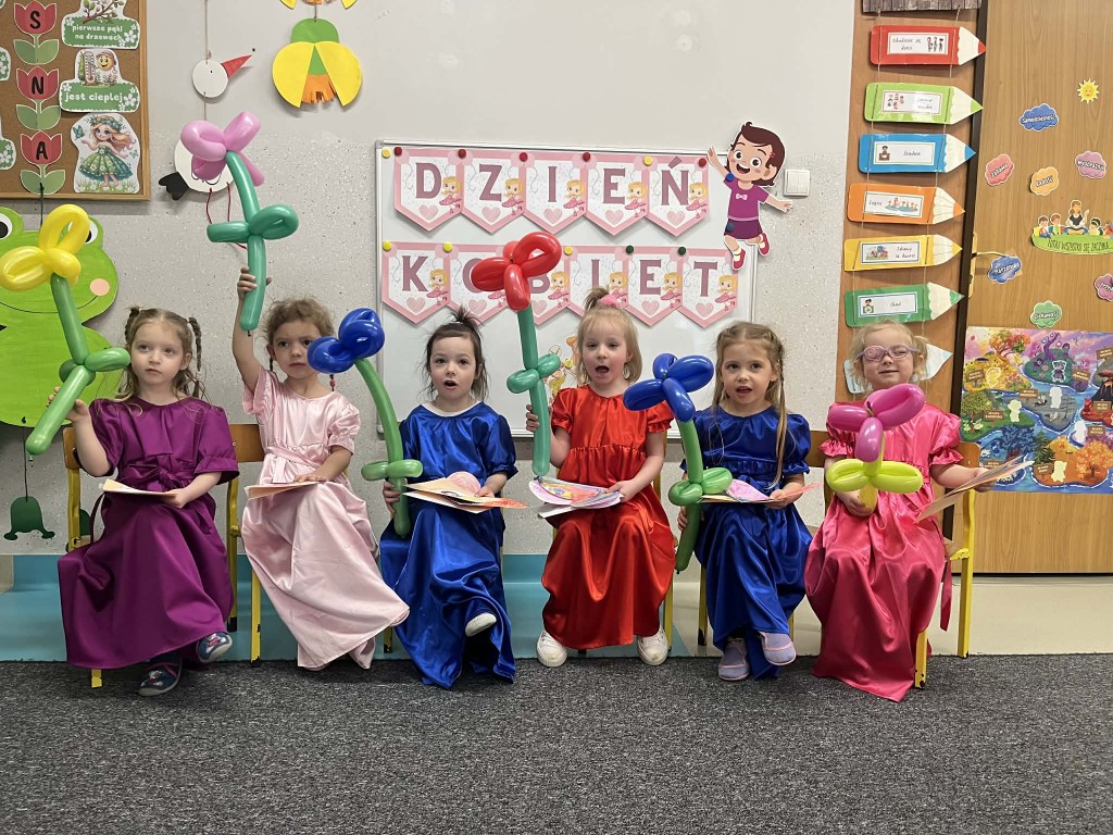 dziewczynki w odświętnych sukniach z kwiatami z balonów