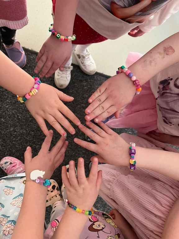 dziewczynki pokazują bransoletki na nadgarstkach
