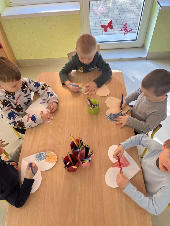 chłopcy przy stoliku ozdabiają serduszka dla dziewczynek