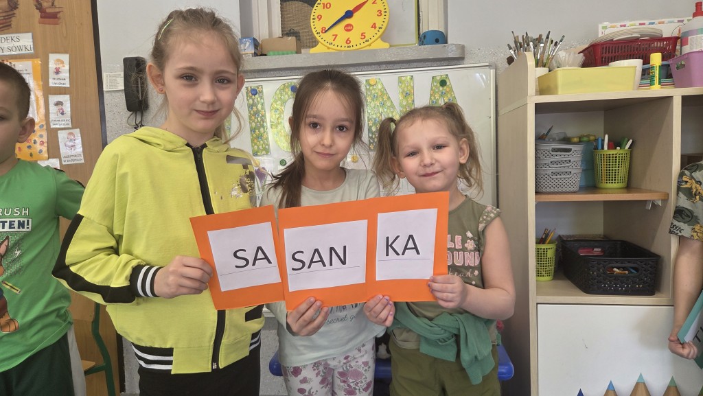 Dziewczynki trzymają napis sasanka