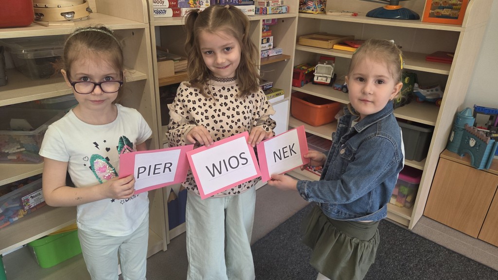 Dziewczynki trzymają napisvpierwiosnek