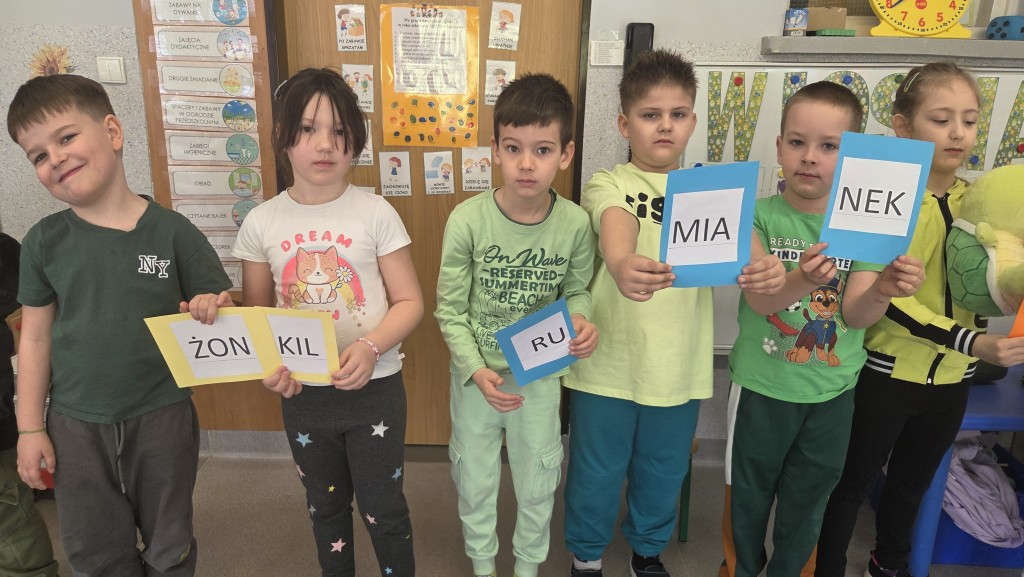 Dzieci trzymają Napisy żonkil i rumianek