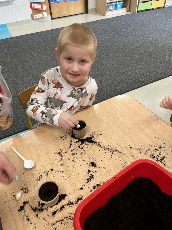 dzieci sadzą cebulkę w ziemi