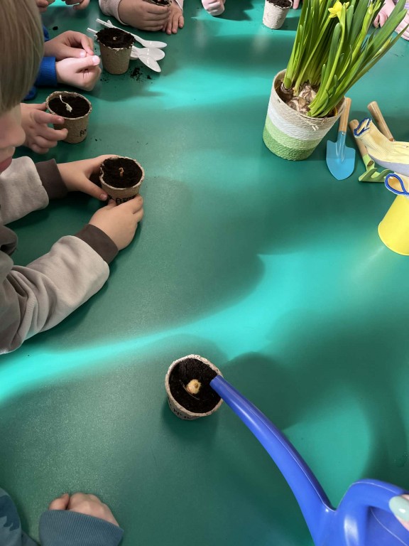 dzieci czekają na podlanie swoich cebulek