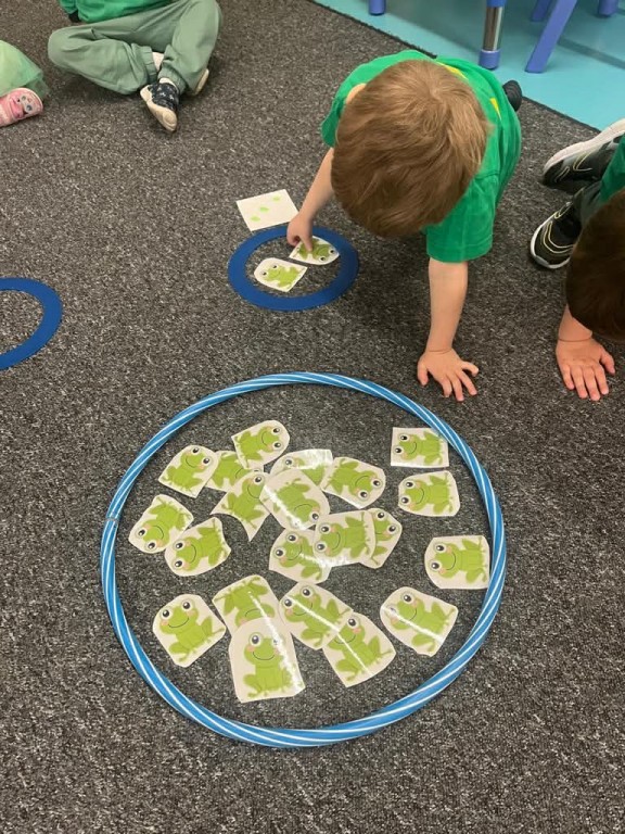 Chłopiec przelicza żabki w dużym stawie