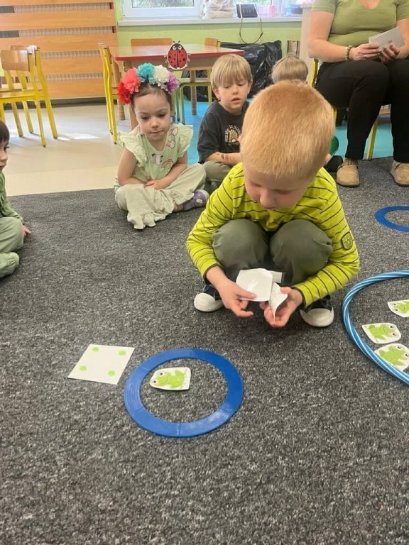 Chłopiec układa żaby