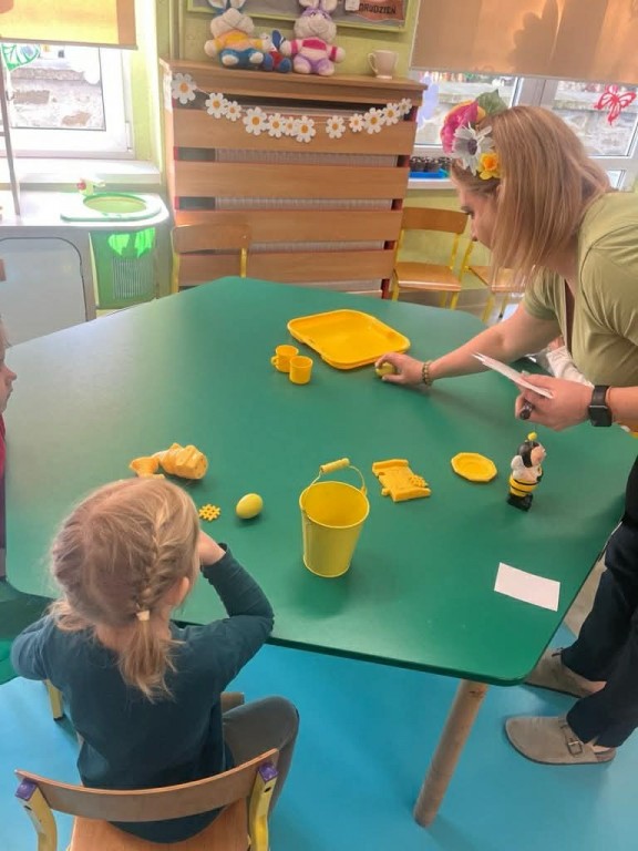 Zabawa - kolorowa wiosna- nauczyciel sprawdza zebrane przez dzieci rzeczy w kolorze żółtym