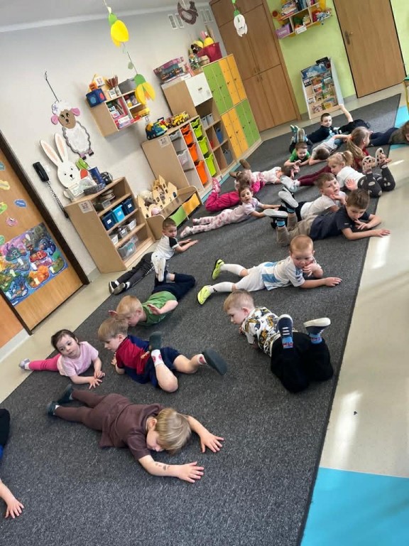 dzieci leżą na dywanie na brzuchu