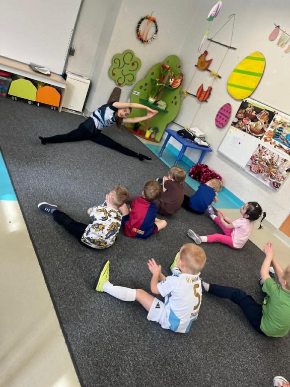 dzieci naśladują ćwiczenia za instruktorką