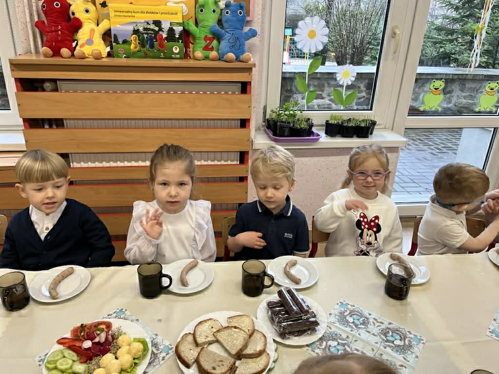 Dzieci siedzą przy zastawionym stole