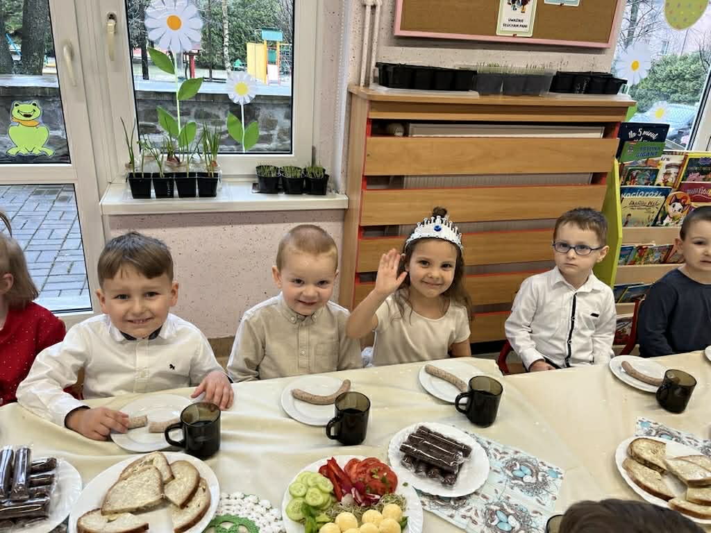 Dzieci siedzą przy zastawionym stole