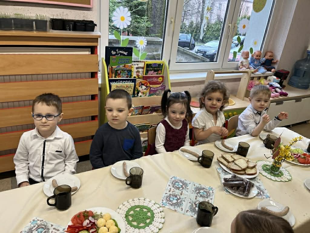 Dzieci siedzą przy zastawionym stole