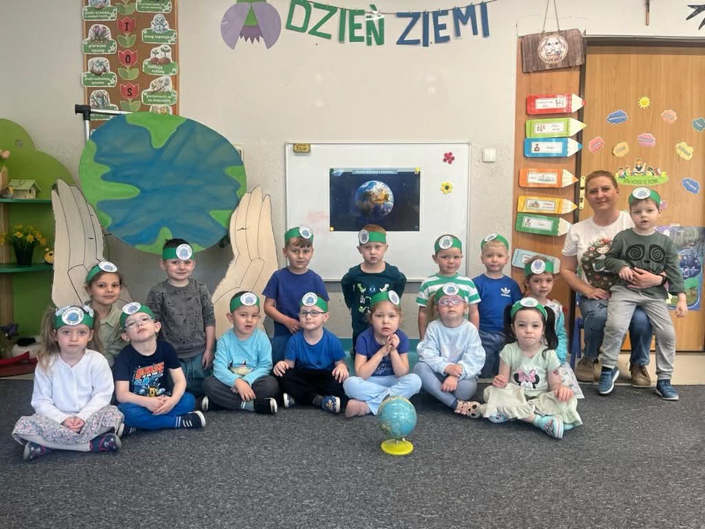 Zdjęcie grupowe dzieci na tle dekoracji z okazji Dnia Ziemi