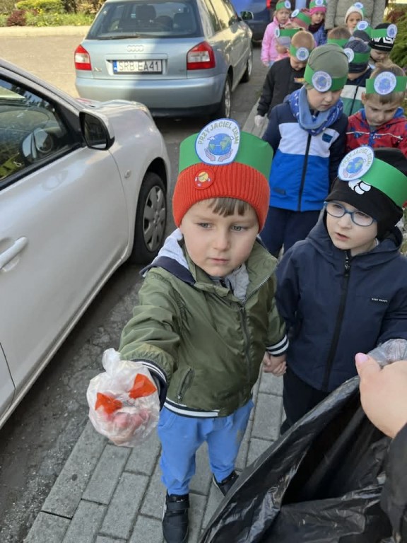 chłopiec pokazuje znaleziony papierek po cukierku