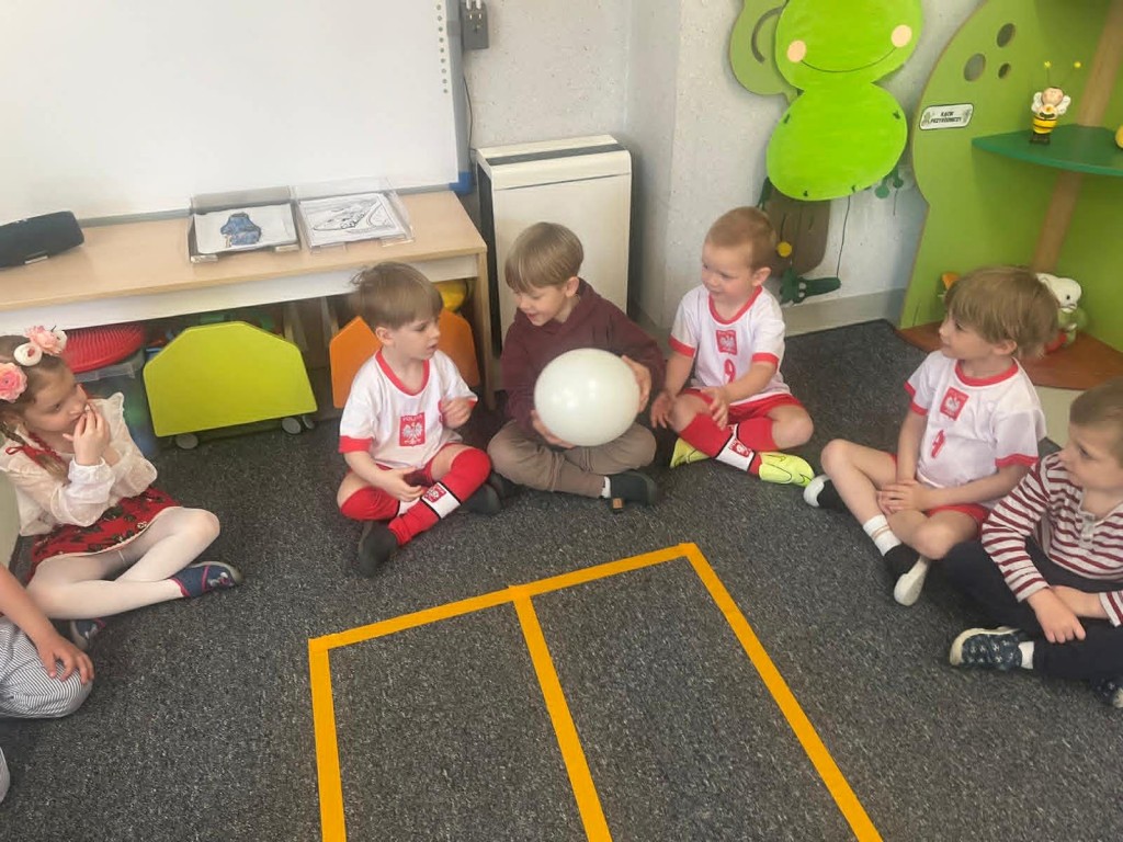 chłopcy podają sobie biały balon