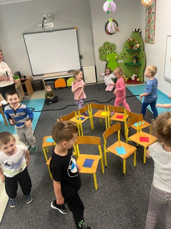 matematyczna zabawa w gorące krzesła, dzieci w rytm muzyki krążą wokół krzeseł