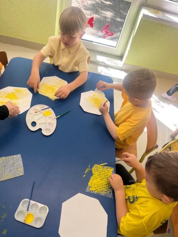 dzieci wykonują pracę plastyczną plaster miodu