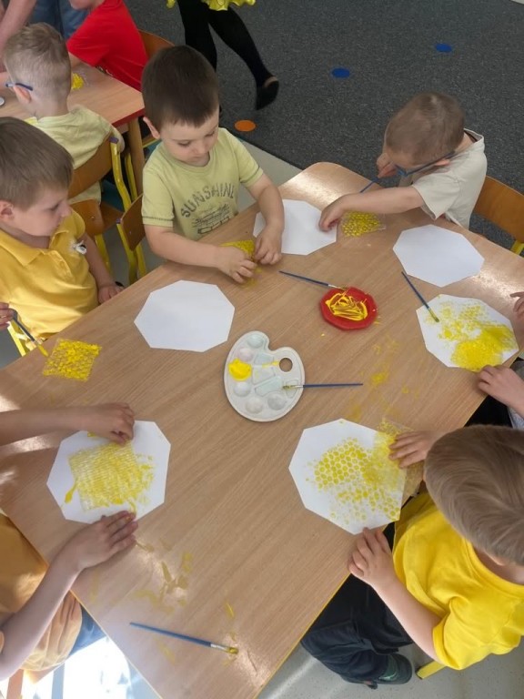 dzieci wykonują pracę plastyczną plaster miodu