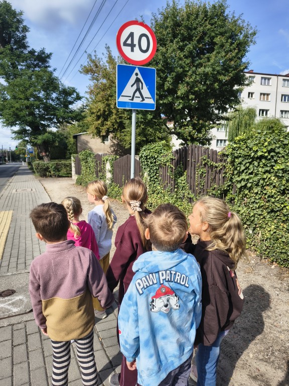 dzieci na spacerze szukaja znakow drogowych i je nazywaja